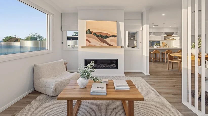 Living room with white roman blinds on the windows either side of the fireplace
