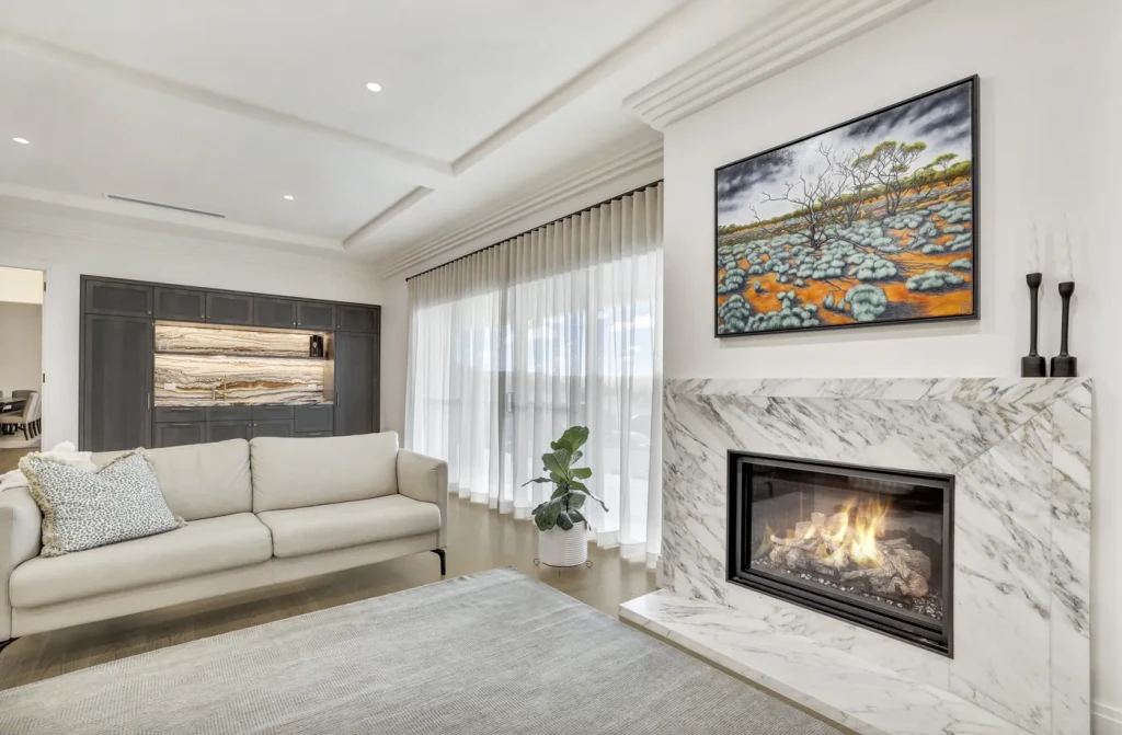 Living room with a marble fireplace and sheer curtains Living room with a marble fireplace and sheer curtains