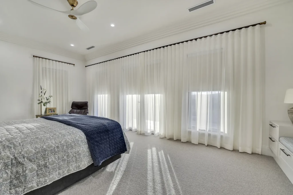 Master bedroom with sheer curtains across the windows Master bedroom with sheer curtains across the windows