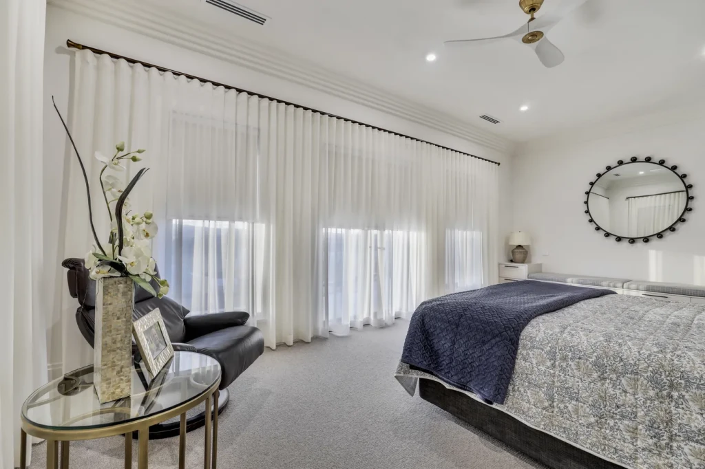 Master bedroom with sheer curtains and a reading chair Master bedroom with sheer curtains and a reading chair