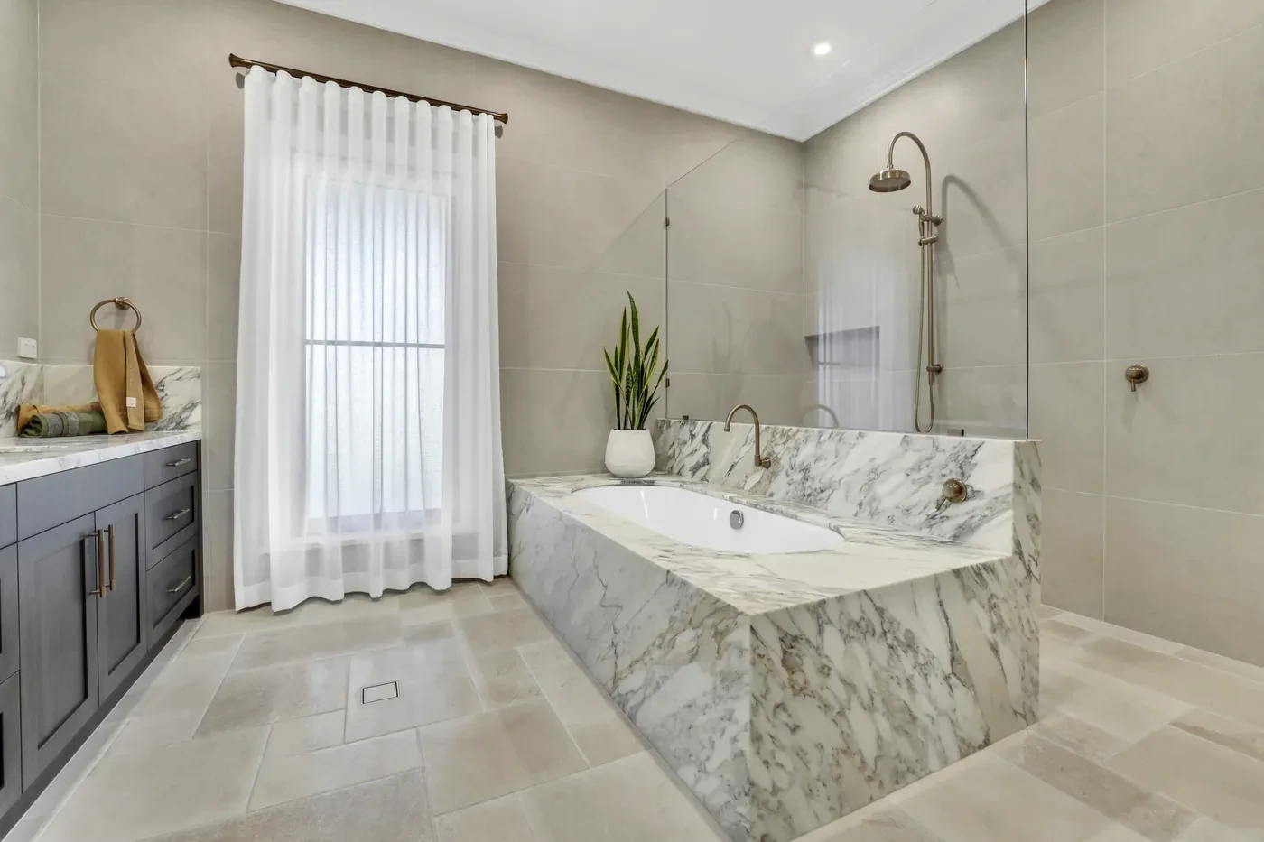 Bathroom with a marble bath and a sheer curtain Bathroom with a marble bath and a sheer curtain