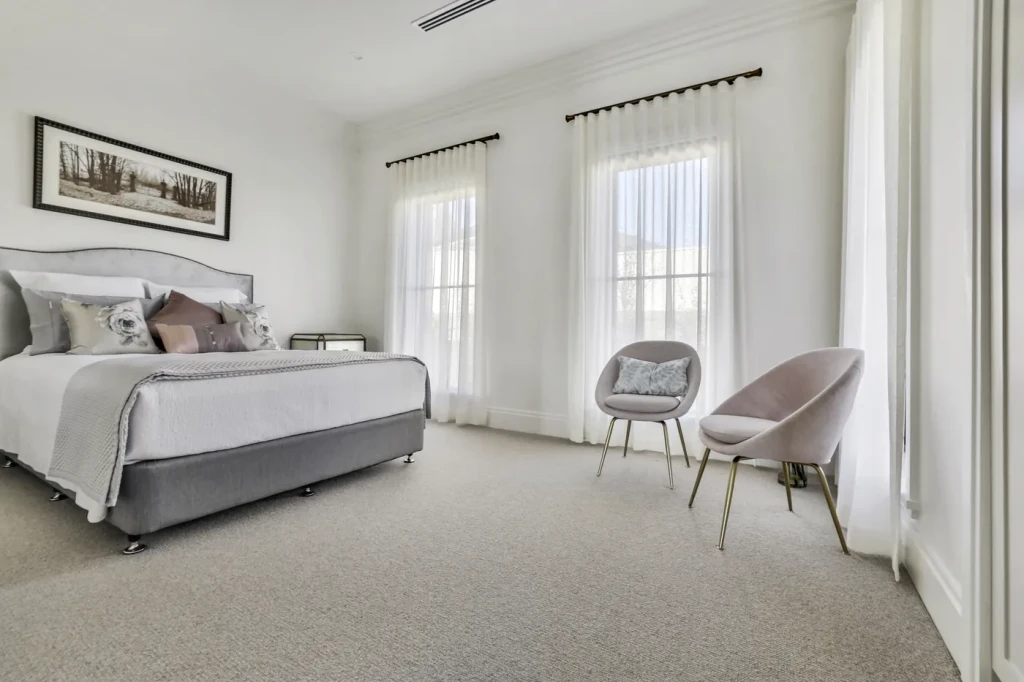 Bedroom with two sheer-curtained windows Bedroom with two sheer-curtained windows