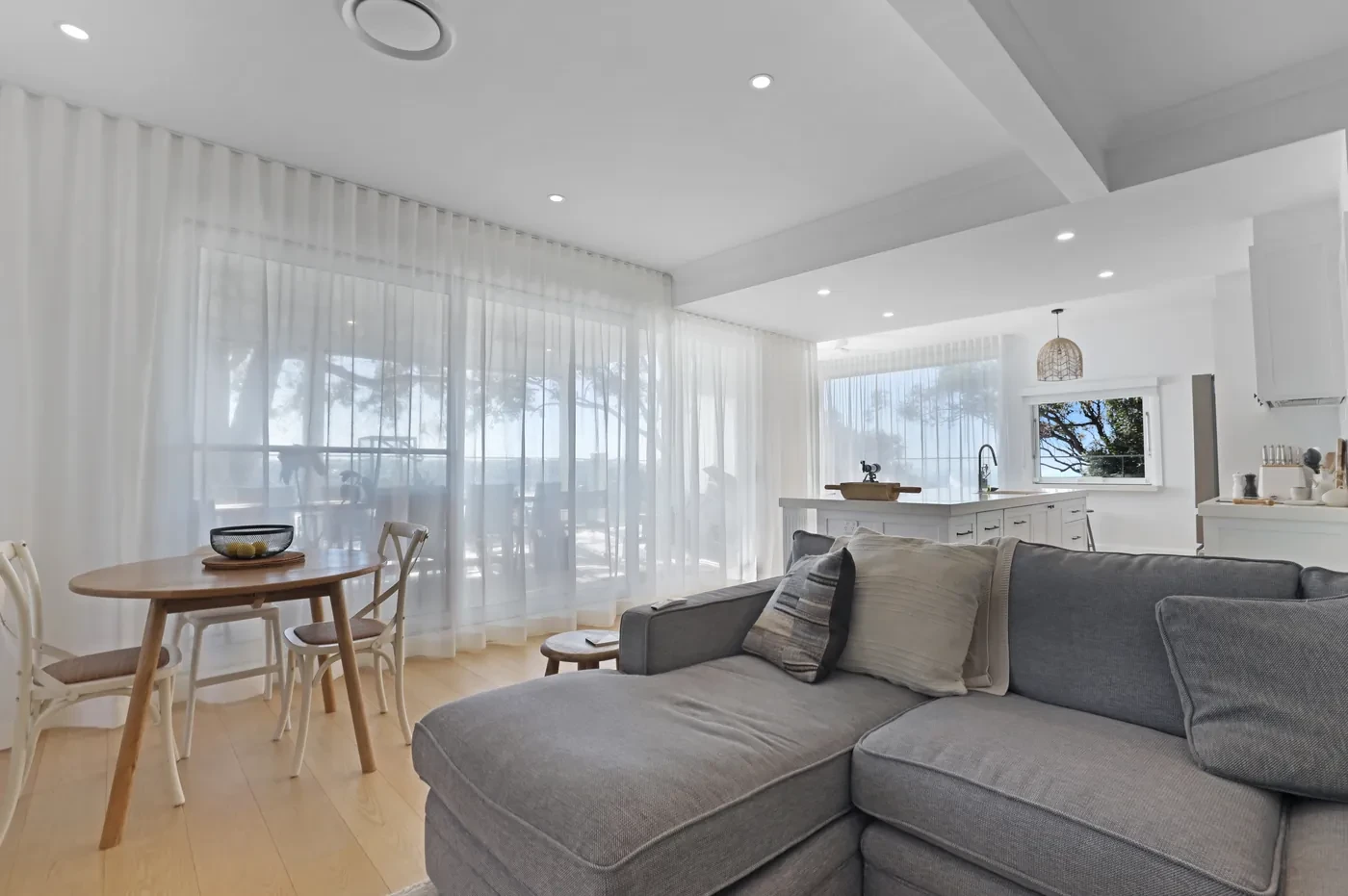 Dining and living area with sheer curtains Dining and living area with sheer curtains