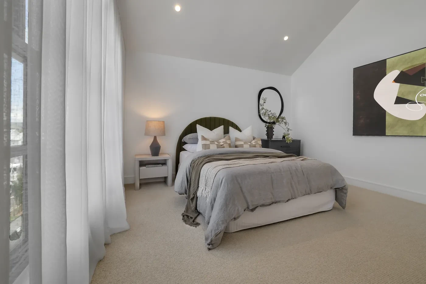 Bedroom with sheer curtains and an arched bedhead Bedroom with sheer curtains and an arched bedhead