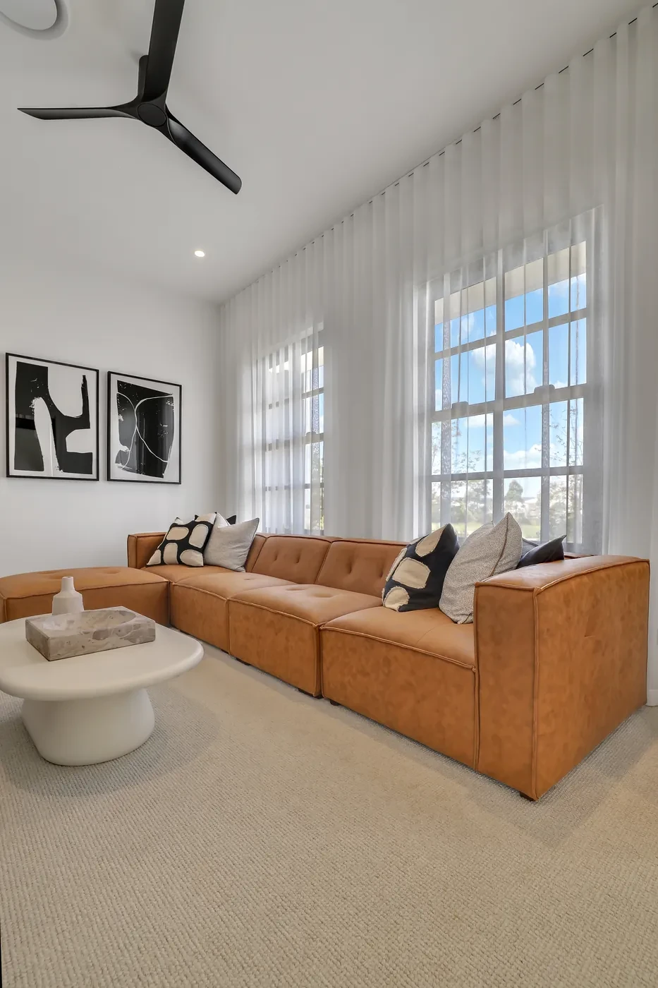 Tan leather lounge with sheer curtains behind Tan leather lounge with sheer curtains behind
