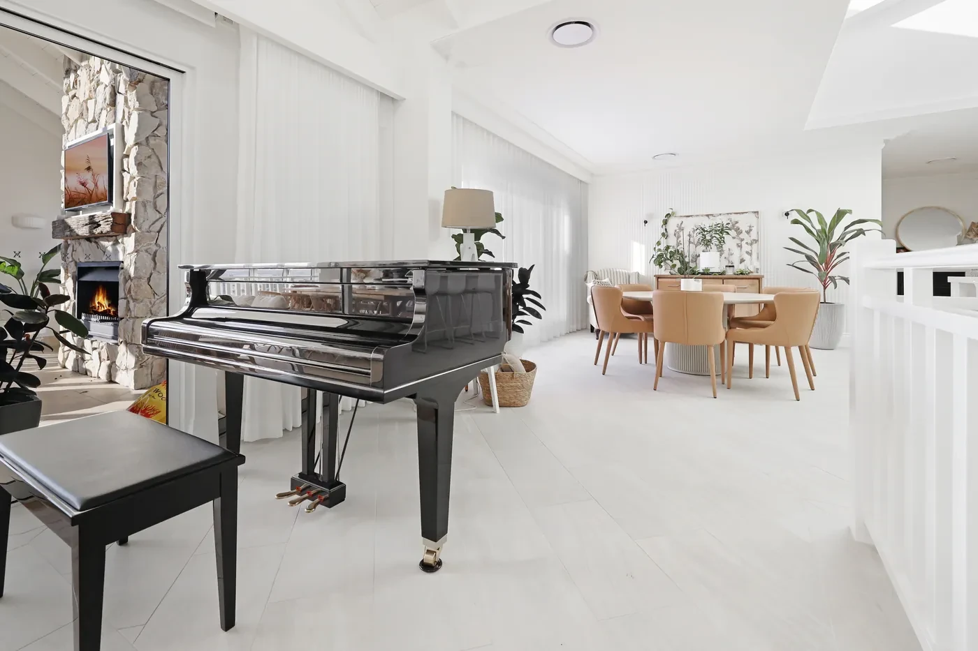 Living and dining room with sheer curtains and a grand piano Living and dining room with sheer curtains and a grand piano