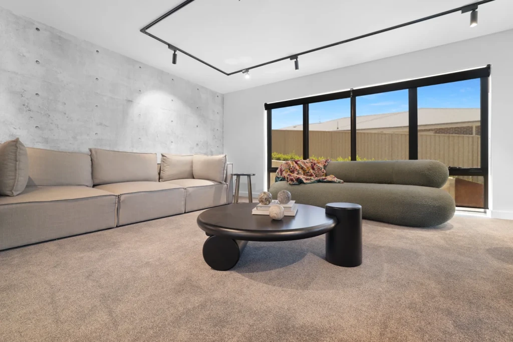 Charcoal sunscreen roller blinds in a concrete-walled living room Charcoal sunscreen roller blinds in a concrete-walled living room