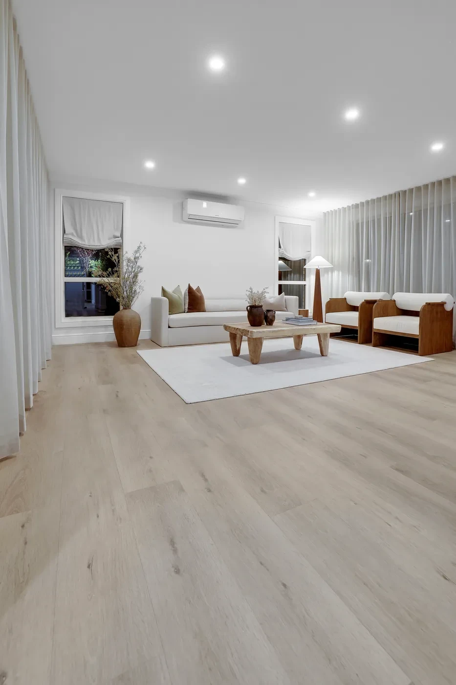 Living room with sheer curtains and timber furniture Living room with sheer curtains and timber furniture