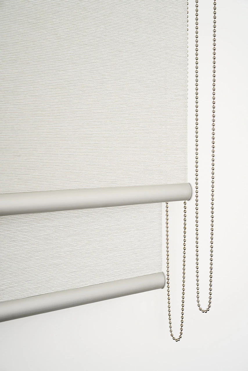 Close-up of a double roller blind: two bottom bars and two chains
