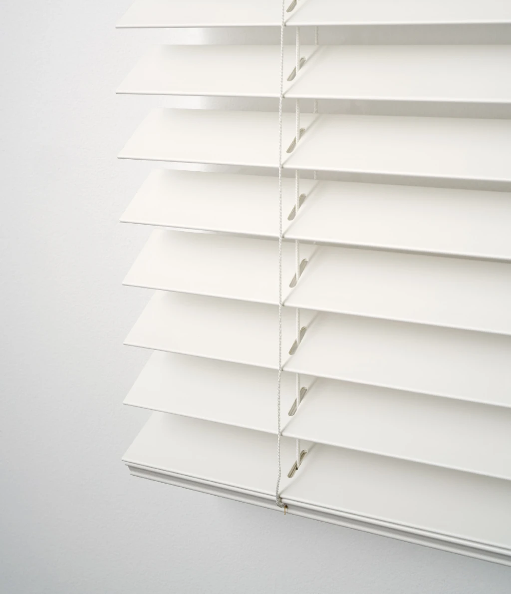 Close-up of white PVC venetian slats, tilted part-open