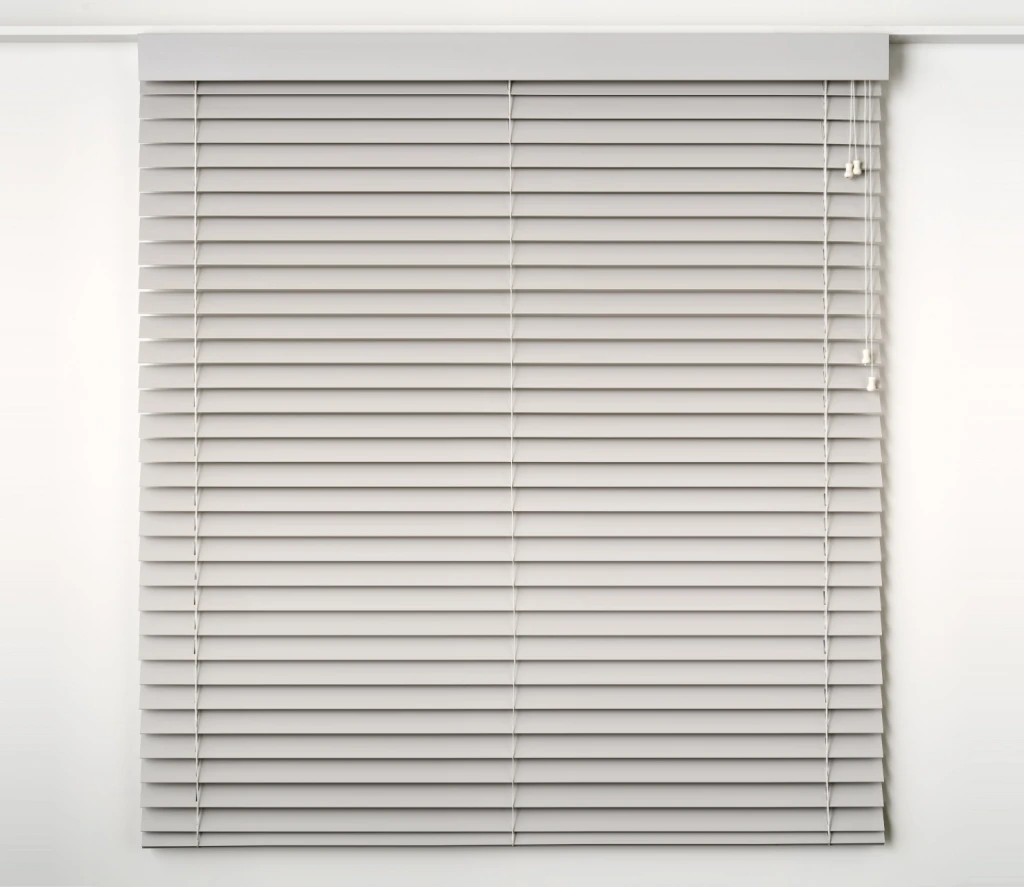 White PVC venetian blind on a white wall, slats open (supplier studio photo)