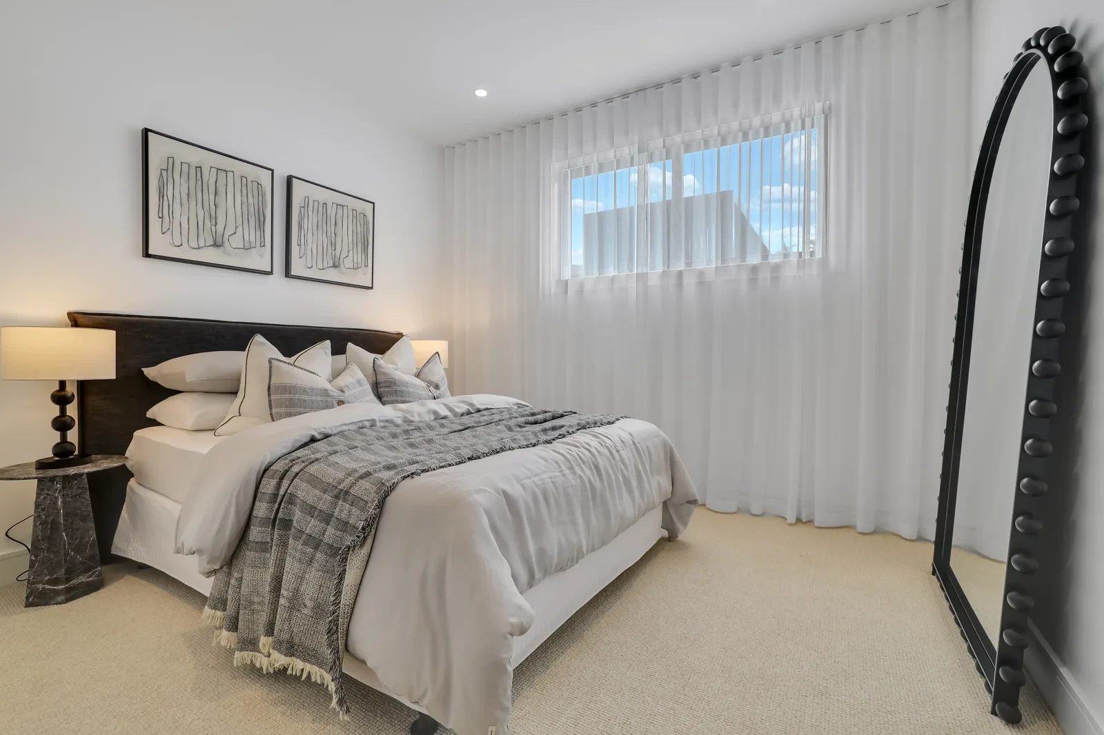 Bedroom with white sheer curtains on a ceiling-fit track