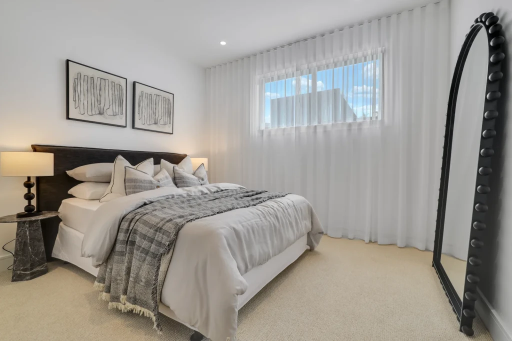 Sheer curtains over a high bedroom window on a ceiling-fit track Sheer curtains over a high bedroom window on a ceiling-fit track