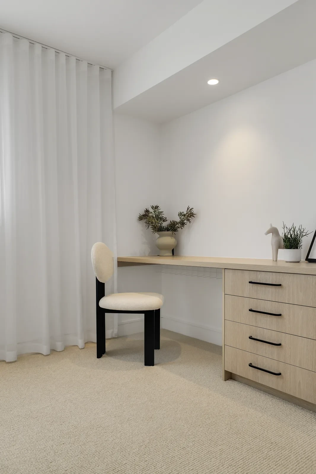 Study nook with a floor-length white sheer curtain on a ceiling-fit track