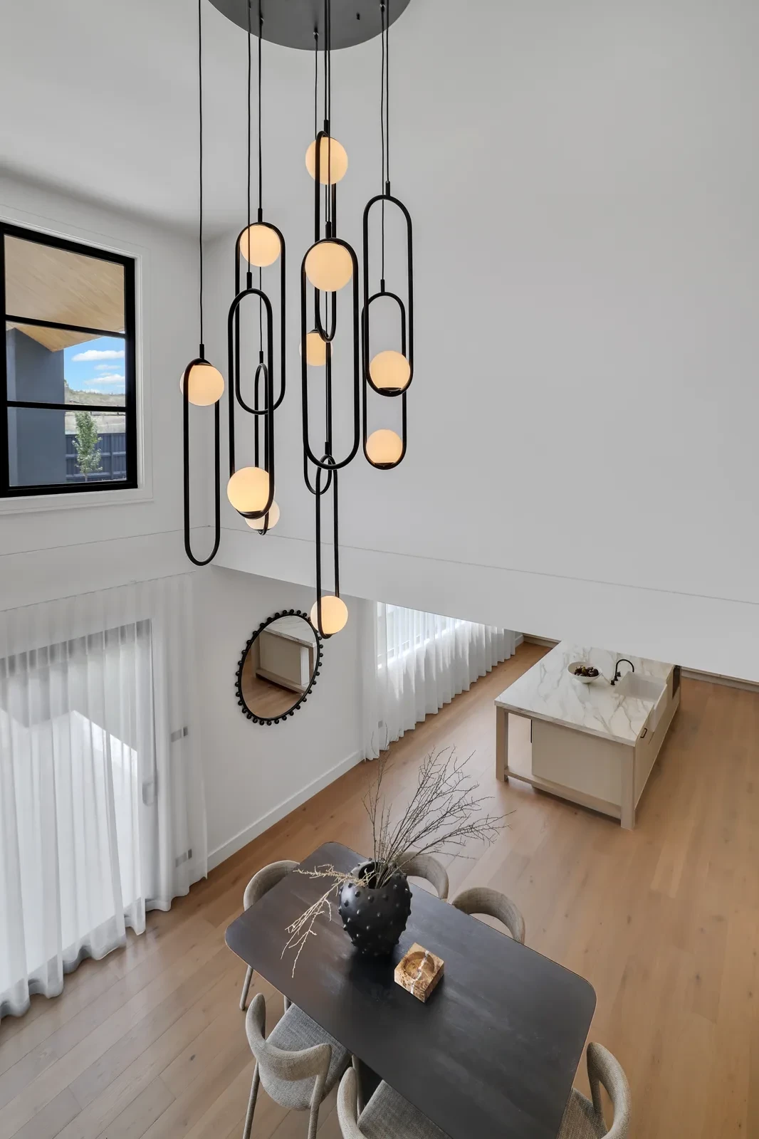 Dining area with pendant light and white sheer curtains