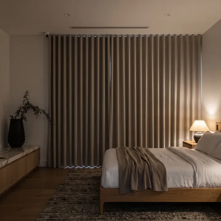 Blockout curtains closed across a bedroom window at night