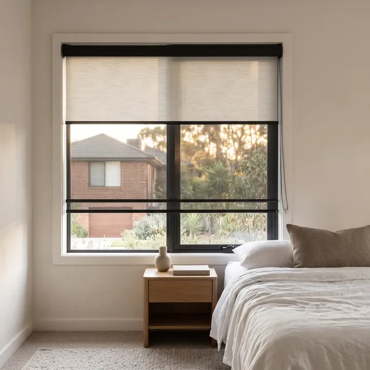Double roller blind in a bedroom, sunscreen and blockout layers on one bracket