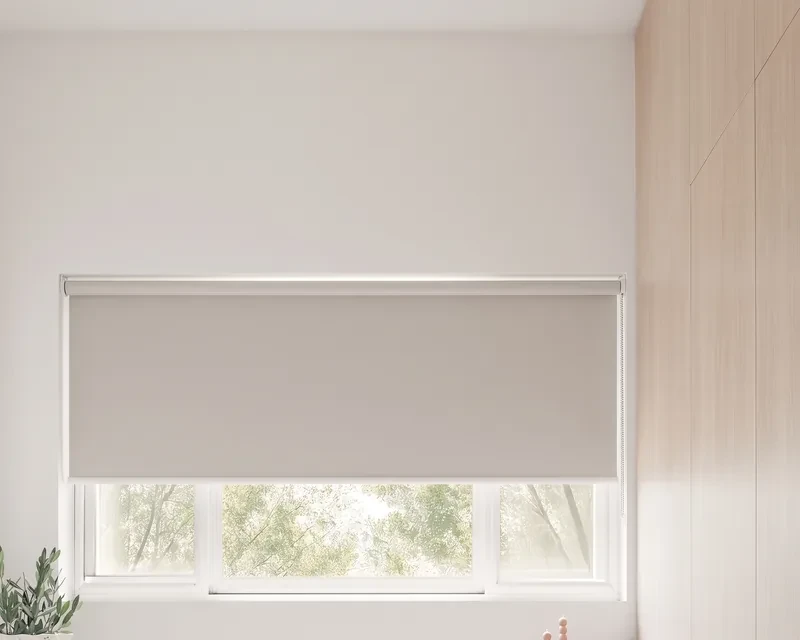 Light grey roller blind fitted inside a study window's recess, lowered two-thirds, chain on the right