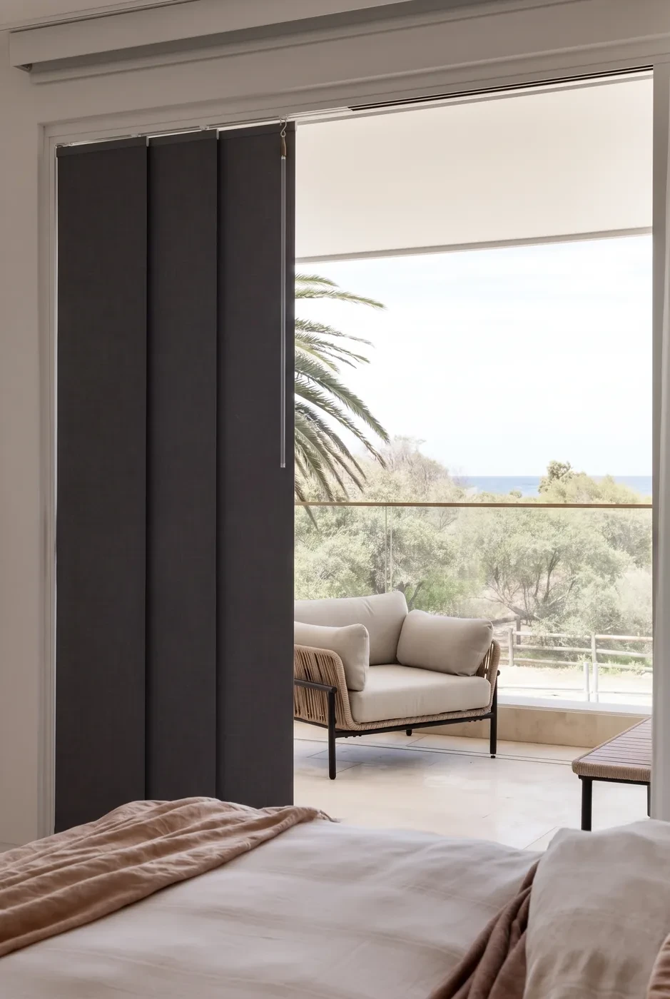 Charcoal panel glide blinds stacked to one side of a bedroom sliding door