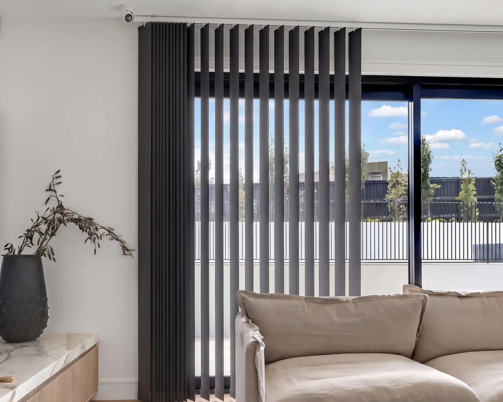Charcoal vertical blind across sliding glass doors in a living room