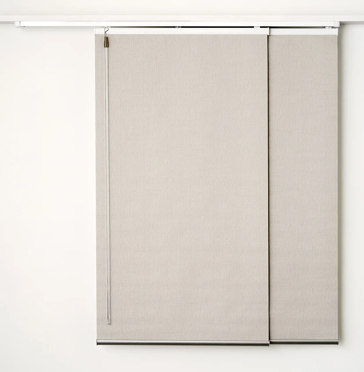 Two light beige panel glide blind panels on a white track, with a wand