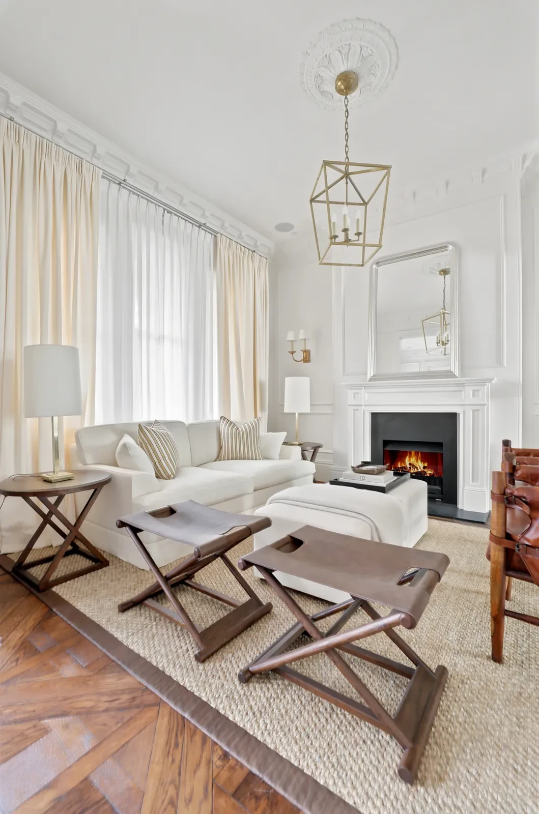 Formal front room with a marble fireplace and full-length curtains layered over sheers on the tall windows