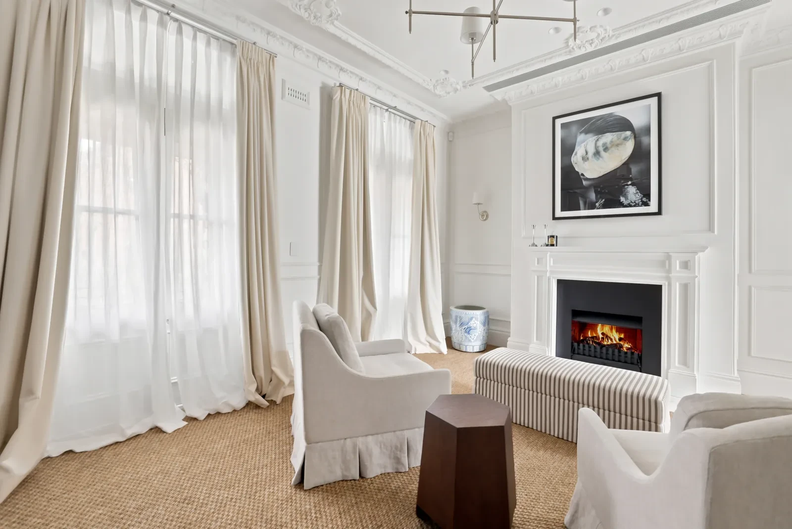 Main bedroom sitting area with layered curtains and sheers either side of the fireplace
