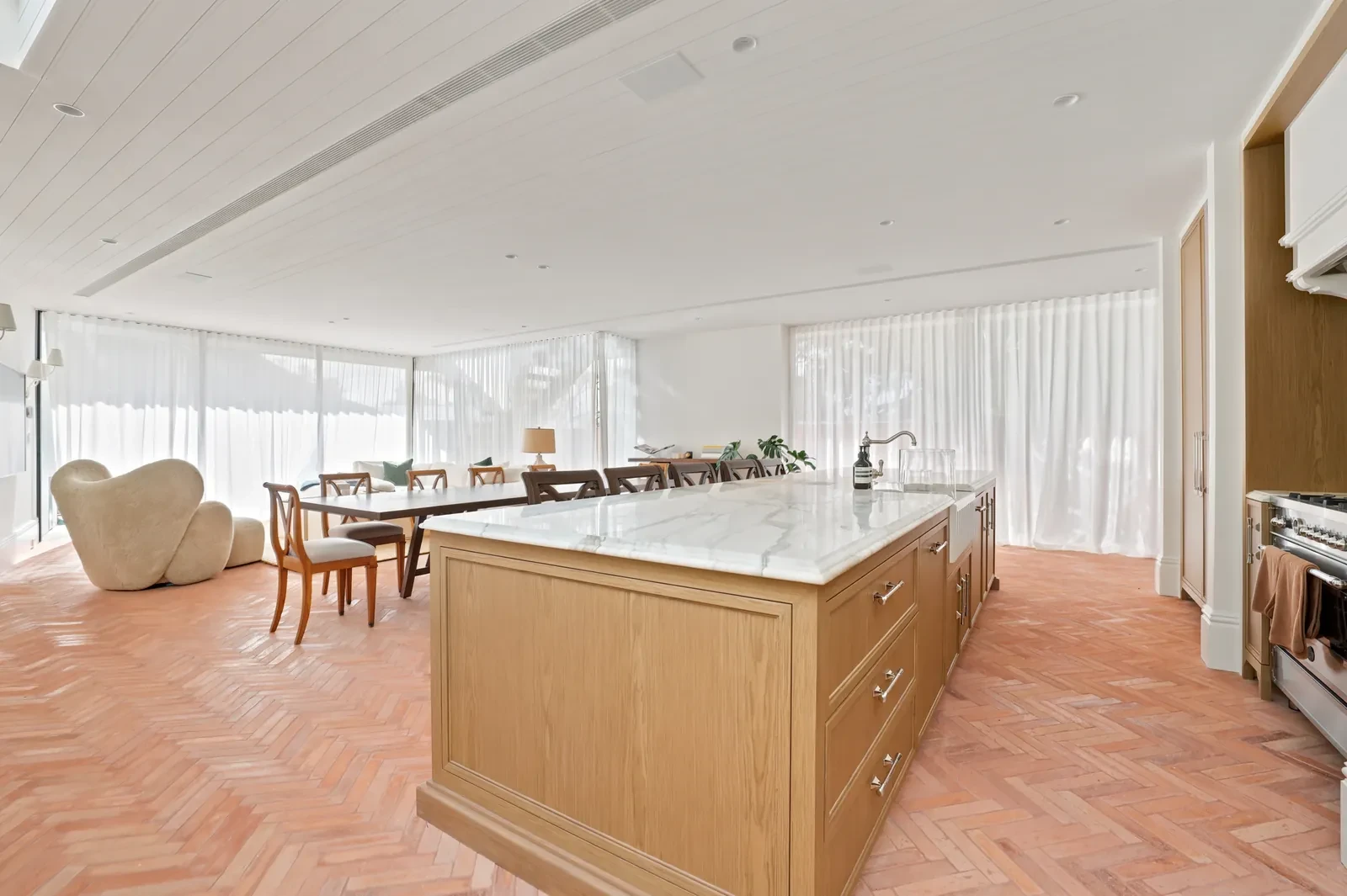 Kitchen island with sheer curtains along the rear windows