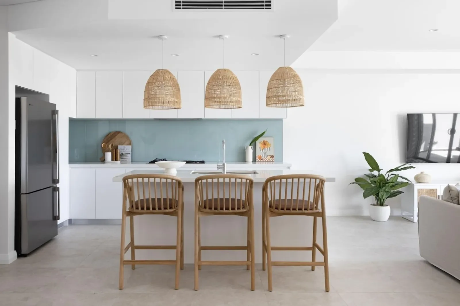 Magenta Palms kitchen with rattan pendants and a sea-green splashback