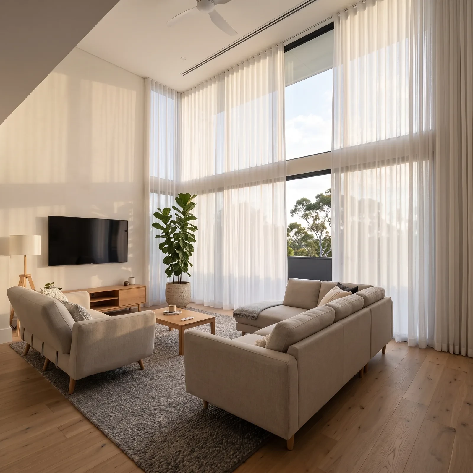Sheer curtains gliding open on a motorised track in a double-height room